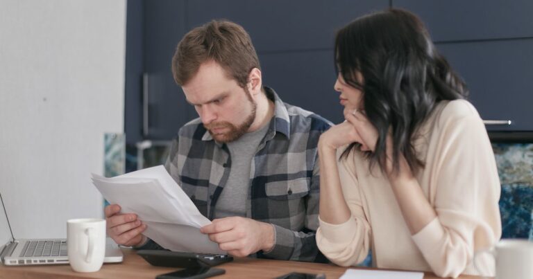 A couple at a table at home reviewing medical aid documents and a hospital account